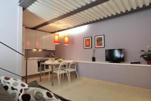 cocina y sala de estar con mesa y TV en Foresteria Pellegrino en Andria