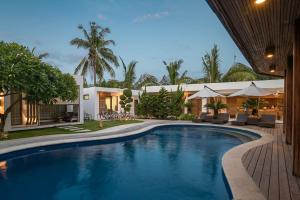 a swimming pool in front of a house at Villa Nero in Gili Trawangan
