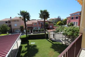 a balcony with a yard with palm trees at Apartments Villa Mattossi in Rovinj