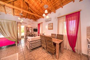 a living room with a table and chairs and a bedroom at Kardamili Villas in Kardamyli