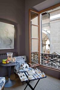 a table with a cat sleeping on it next to a window at Porcellino Gallery Art Boutique BB in Florence
