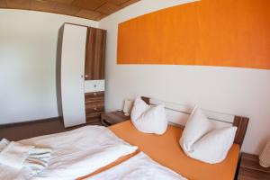 Schlafzimmer mit einem Bett mit weißer Bettwäsche und Kissen in der Unterkunft Hotel Waldoase Hirschbüchenkopf in Güntersberge