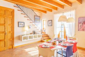 een eetkamer met een tafel en stoelen en een trap bij Historical House Palma in Palma de Mallorca