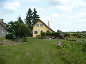 ein gelbes Haus mit einem Rasenplatz davor in der Unterkunft Ranczo Ryn in Ryn