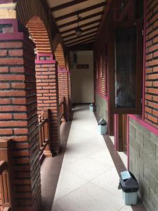 an empty hallway of a building with brick walls at Omah Wetan Homestay in Malang