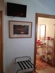 a room with a tv on the wall and a chair at Manta Rota Beach, Bed & Breakfast in a villa,privat pool in Manta Rota