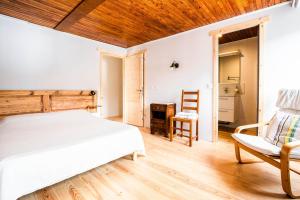 een slaapkamer met een bed en een stoel bij Maison Sarda in Formiguères