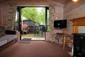 ein Wohnzimmer mit einer Glasschiebetür zur Terrasse in der Unterkunft Fellside Lodge in Keswick