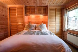 1 dormitorio con 1 cama grande en una habitación de madera en Fellside Lodge, en Keswick