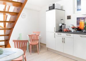 a kitchen with white cabinets and a table and chairs at Träumerei in Laubach