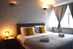 une chambre avec un grand lit avec des oreillers jaunes dans l'établissement Whitburn House Hotel, à Preston
