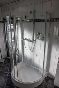 y baño con ducha y puerta de cristal. en Hotel Gasthof Zur Post, en Albersloh