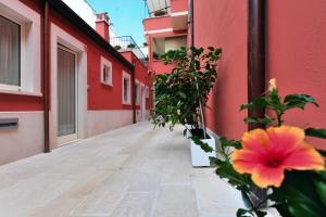 un edificio rosa con una flor en el costado en Foresteria Pellegrino en Andria