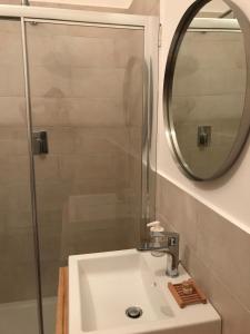 La salle de bains est pourvue d'un lavabo, d'une douche et d'un miroir. dans l'établissement B&B CASA GILANIA LAMPEDUSA, à Lampedusa