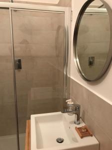 W łazience znajduje się umywalka z prysznicem i lustrem. w obiekcie B&B CASA GILANIA LAMPEDUSA w mieście Lampedusa +22 zdjęcia