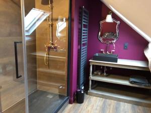 a bathroom with purple walls and a staircase with a mirror at Les Gîtes Ecosphère in Genappe