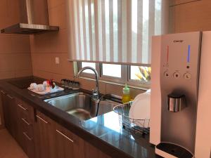 a kitchen with a stainless steel sink and a window at Fuuka Villa in Pantai Cenang