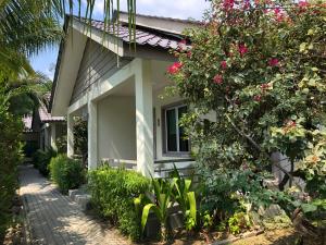 a house with pink flowers on the side of it at Fuuka Villa in Pantai Cenang