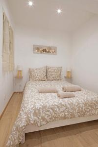 a bed in a white room with two lamps at Au coeur du Panier - Vieux Port in Marseille