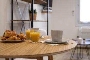 uma mesa com um prato de comida e dois copos de sumo de laranja em Au coeur du Panier - Vieux Port em Marselha