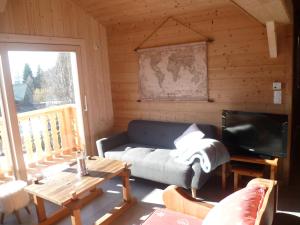 ein Wohnzimmer mit einem Sofa und einem TV in der Unterkunft MOUFFLON in Verchaix