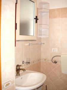 La salle de bains est pourvue d'un lavabo et d'un miroir. dans l'établissement Monolocale Loredana, à Tergu