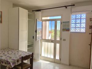 a room with a door with a table and a window at Monolocale Loredana in Tergu