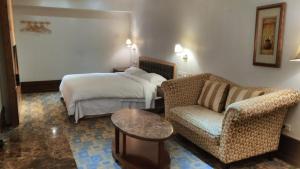 una camera d'albergo con un letto, un divano e una sedia di Kai Wei Boutique Hotel a Taipei