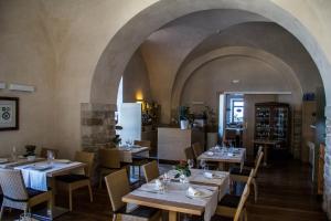 a restaurant with tables and chairs and an archway at Palazzo Filisio - Regia Restaurant in Trani