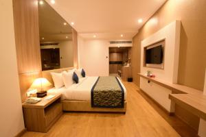 a hotel room with a bed and a television at SureStay Plus Hotel by Best Western Amritsar in Amritsar