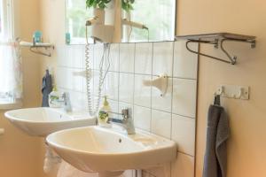 uma casa de banho com 2 lavatórios e um espelho em Hasselö Hostel em Hasselö