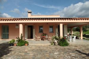 a house with a patio and a table and chairs at Agriturismo Sa Mandria in Castiadas