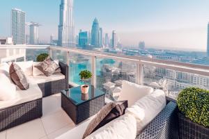 einen Balkon mit weißen Möbeln und Stadtblick in der Unterkunft Elite Royal Apartment - Burj Residences T7 - President in Dubai