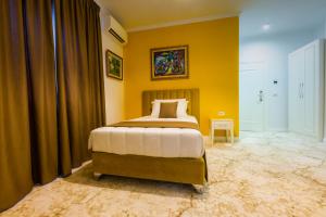 a bedroom with a bed and a yellow wall at ART Hotel Tirana in Tirana