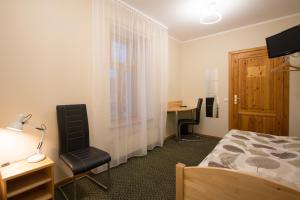 a bedroom with a bed and a desk and a chair at Hotel Katrina in Cēsis