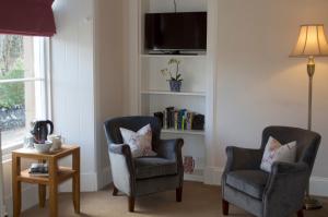 sala de estar con 2 sillas y TV en Balnearn House en Aberfeldy