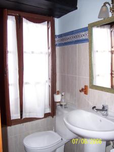a bathroom with a toilet and a sink and a mirror at Las Medulas Los Telares in Las Médulas