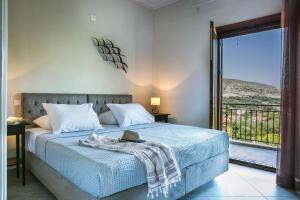 a bedroom with a blue bed with a balcony at Cephalonian Countryside Villa in Divarata