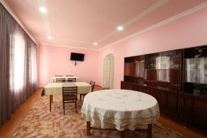 Habitación con 2 mesas y TV en la pared. en Guesthouse ''Ashot Shalunts'', en Goris