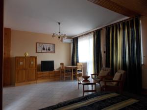 a living room with a couch and a table and a television at Heviz Therme Apartmenthaus in Hévíz
