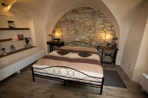 Ce lit se trouve dans un dortoir doté d'un mur en pierre. dans l'établissement Apartmán U Gotického dvojčete, à Litoměřice