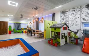una sala de juegos con una casa de juguetes y una mesa en Hotel Krynica Conference & SPA, en Krynica-Zdrój