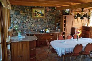 a kitchen with a table and a counter with chairs at Dom na wodzie Mazury in Dźwierzuty