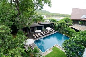 an overhead view of a swimming pool with chairs and umbrellas at Kireethara Boutique Resort in Chiang Mai
