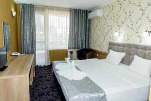 a hotel room with a bed and a television at Family Hotel Prestige in Burgas