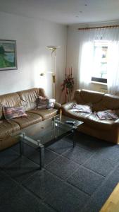 a living room with two brown couches and a table at Ferienwohnung St. Wigbert in Fritzlar