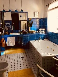 bagno piastrellato blu con vasca e lavandino di Villa Aspilon a Drama