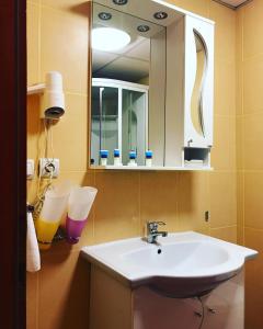 bagno con lavandino bianco e specchio di Hotel Francesca a Timişoara