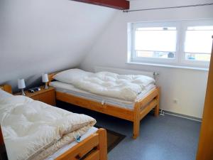 two twin beds in a room with a window at Ferienhaus Krabbe in Friedrichskoog-Spitze/ Nordsee in Friedrichskoog