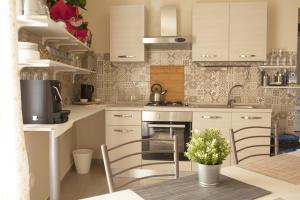 a kitchen with a stove and some chairs in it at La Regina Di Saba in Piazza Armerina